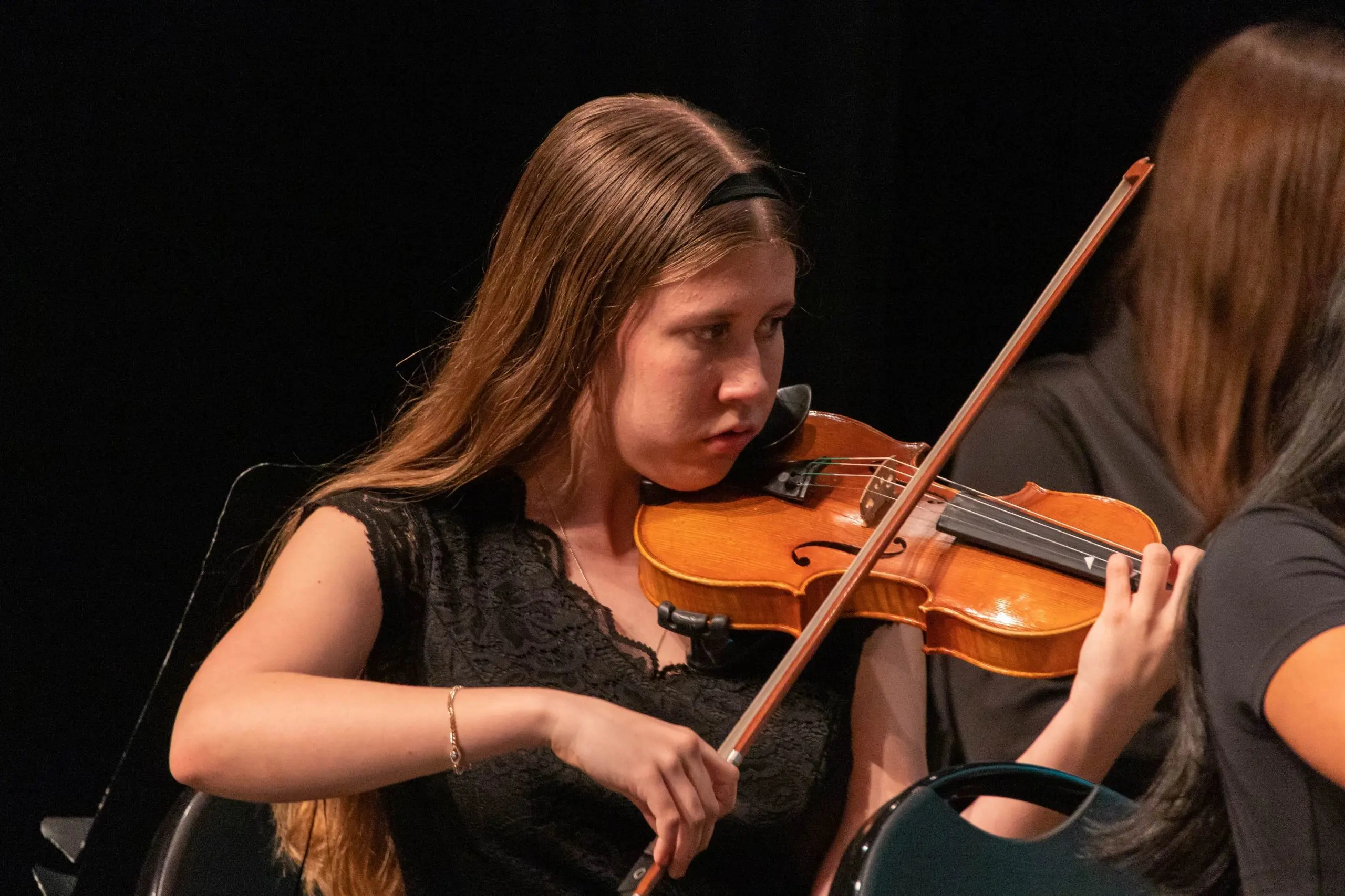 Loyola Academy student performing on the violin during a music rehearsal or concert.