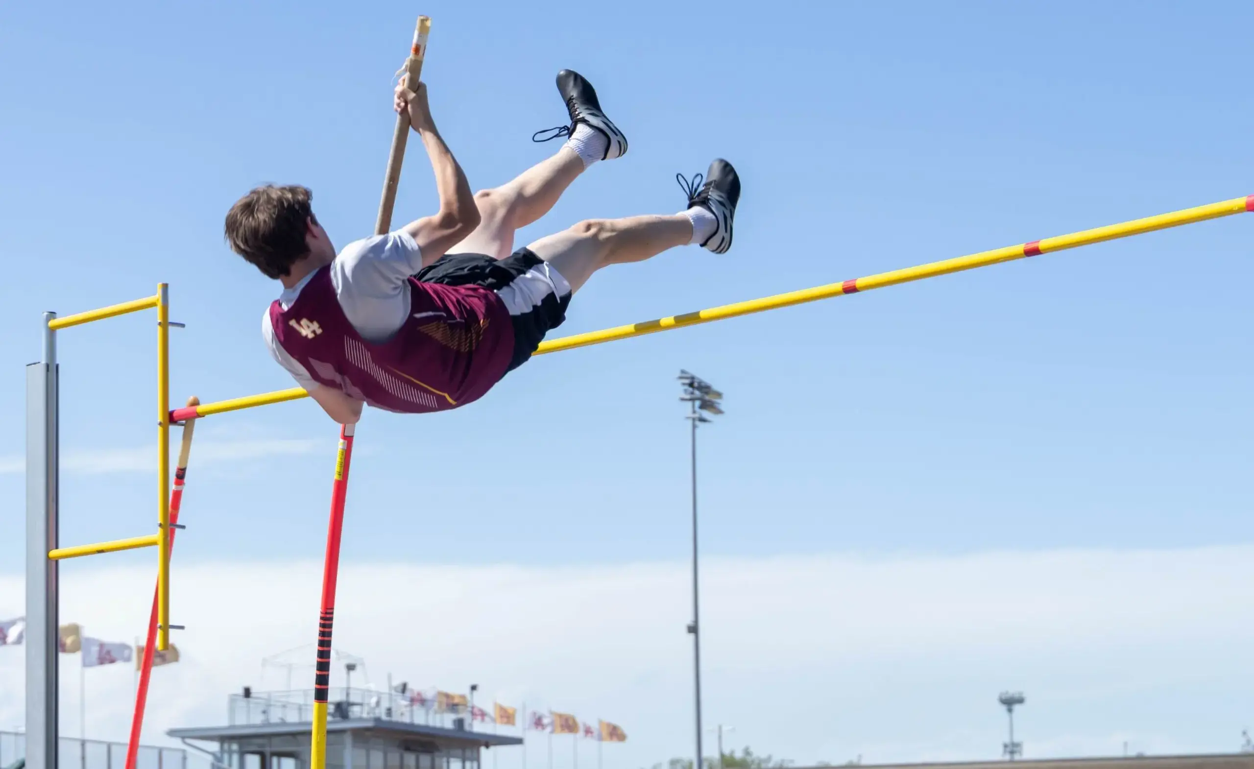 Male student doing high jump